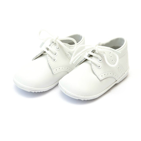 James is one of our oldest styles, a tribute to classic shoes in sturdy leather. This is our favorite go to shoe for any occasion, from Easter to Baptism to Christmas. Fit your little gent's toes into this shoe, and he will be charming everyone coming his way.  Leather upper Functional lace through tonal grommets Simple brogue detailing and trim