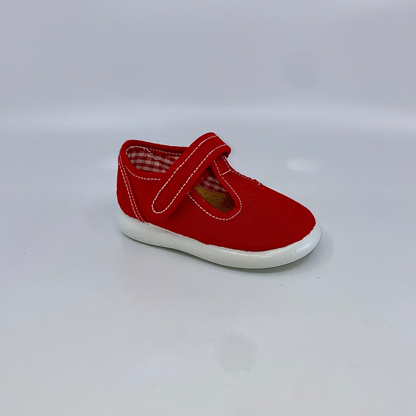 Canvas -Lightweight and comfy T strap in red canvas  upper - velcro strap -Textile lining and padded insole. - Smooth traction rubber sole -Rounded toe -Made in Spain