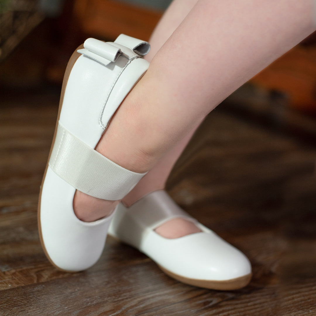 Who knew comfort could look so good? The magic is in the details of Aria, featuring the highest quality leather, the perfect complement to a tutu or a garden party. A soft padded collar adds support for the heel, while a suede bow adds a touch of style and surprise. It's the last thing you'll see as she darts away! Sweet yet functional satin elastic with an extra soft suede backing provides support and all-day comfort. 