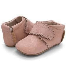 A darling and easily matchable boot for baby, Fleur offers a single hook-and-loop closure that make for easy on and off.  Stage: crawling Suede shimmer upper Natural leather lining Adjustable hook and loop closure for a tailored fit Padded elastic collar for easy on and off Tan suede sole with black recycled rubber tread circles Best suited for indoor use and light outdoor activity APMA approved sole